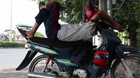 Man sleeping on a motorcycle Stock Footage 58626238