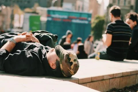 Man sleeping at the park while enjoying the sun Stockfoto's