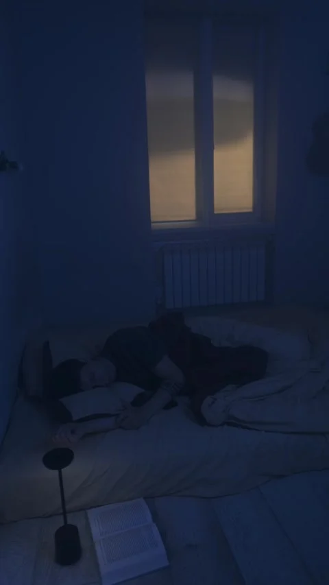 Man sleeping peacefully at night after reading book, soft night lamp and calm Stock Footage 321079607