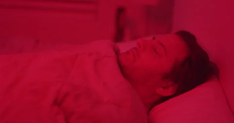 Man sleeping red lights alien abduction ghost bedroom Stock Footage 249308543