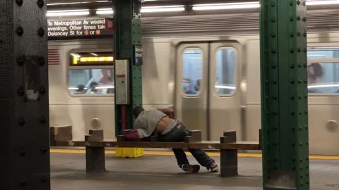Man sleeping on subway train station platform bench West 4th Street New York Stock Footage 162994829