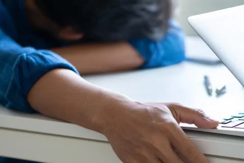 Man sleeping on table, laptop on table, man tired from work Stock Photos