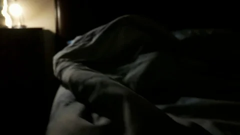 A man sleeps alone in a double bed, camera moves close to face Stock Footage 102232578