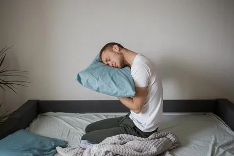 A man sleeps funny in bed Stock Photos