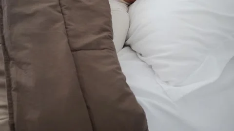 A man sleeps on a snow-white bed. Sweet morning dream. 스톡 동영상 133417819