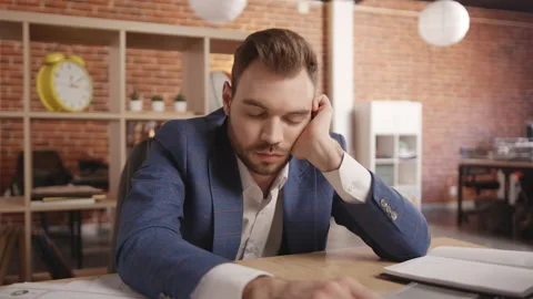 A man sleeps at the table, then wakes up and writing in a notebook Vidéo 188792222
