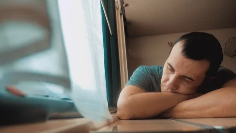 Man sleeps in train tired long journey by rail. train railroad journey travel Stock Footage 106540180