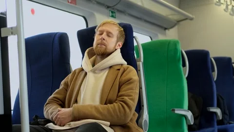 A man sleeps while sitting in a train chair Stock Footage 313815742