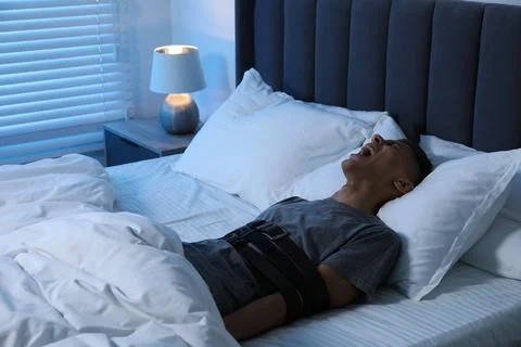 Man in sleepwalking condition screaming in bed 库存照片