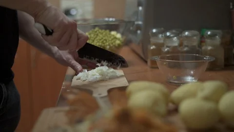 Man slice fresh onion in the kitchen table, preparing vegetable  salad. Stock Footage 123258511