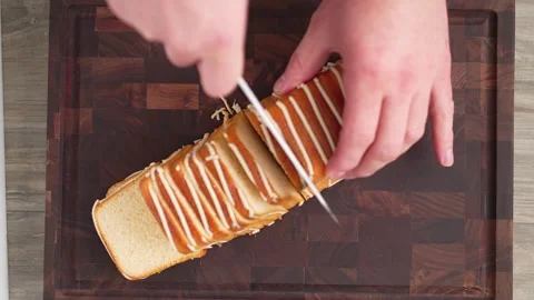 A man slices a baked roll in side view Stock Footage 261170801