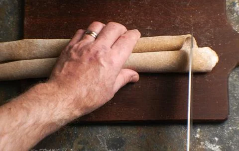 Man slices a dough for a paste with a knife Stock Photos