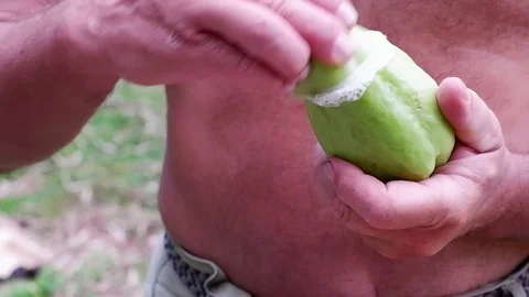 A man slices a green vegetable. Video stock 122924496