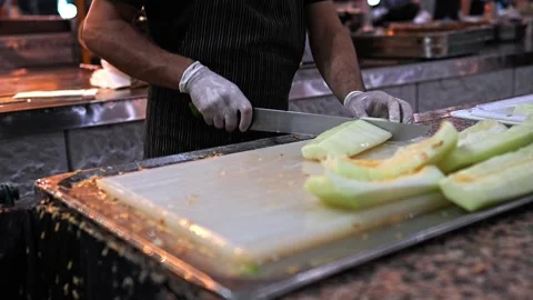 A man slices melons with a knife Stock Footage 284002726