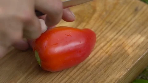 Man slices red pepper with a knife Stock Footage 80236700