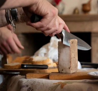 Man slicing a block of lard with a chefs knife Stock Photos