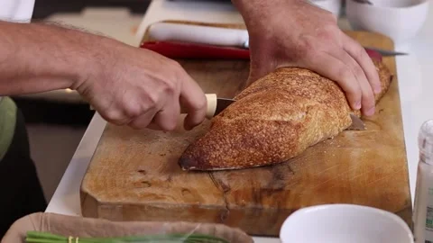 Man slicing bread on a table Stock Footage 153766003