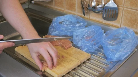 Man slicing chicken meat on the cutting board Stock Footage 87306820