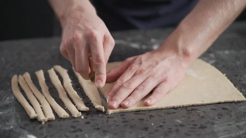 Man slicing flat dough with knife for making grissini Stock Footage 124770972