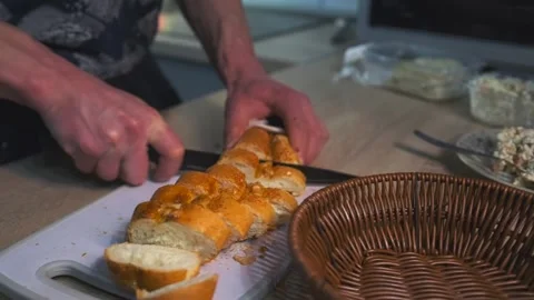 Man slicing fresh white bread on cutting board, close-up side view Stock Footage 315068172