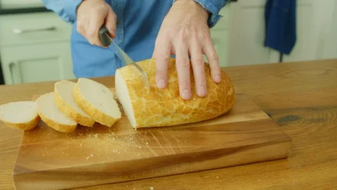 Man Slicing Freshly Baked Bread With Knife On Chopping Board Video stock 86115350