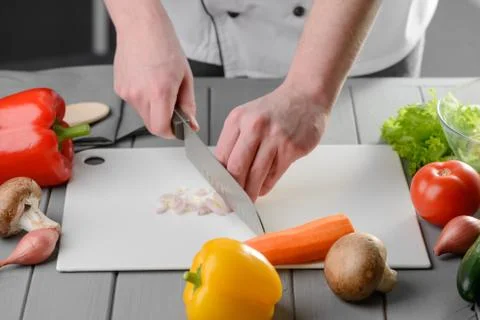 Man slicing an onion with a chef's knife Stock Photos