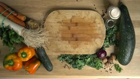 The man is slicing peppers on a table full of fresh vegetables.  Stock Footage 142577559