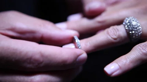 Man slides diamond wedding ring on woman's finger Stock Footage 48578716