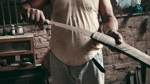 Man slides large kukri knife into a wooden sheath Stock Footage 162949869