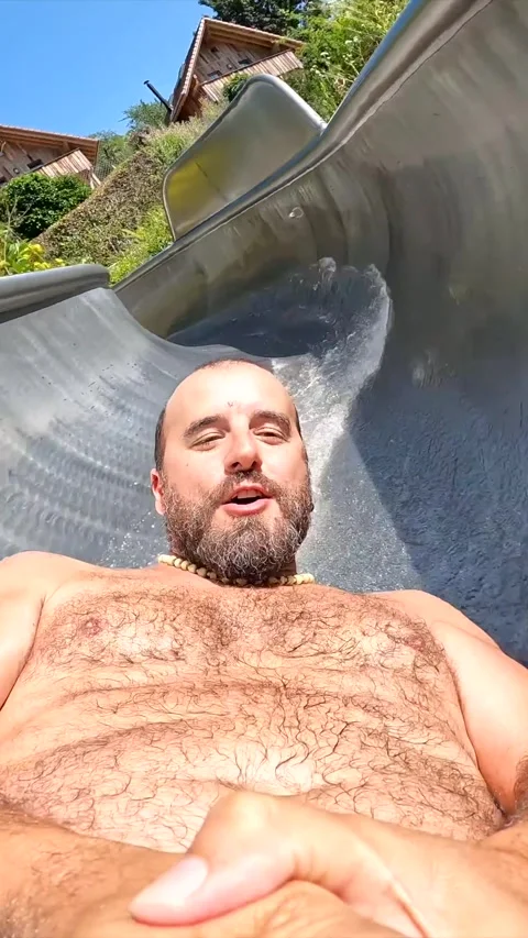 A man is sliding down a water slide with his hands on his hips Stock Footage 308751974