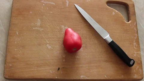 Man is slitting a tomato Video stock 77589804