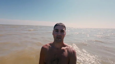 The man slowly falls backwards into the sea water. Stock Footage 316845997