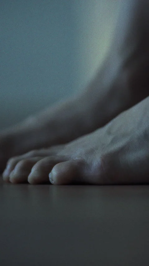 As man slowly rises from bed his bare feet touch wooden bedroom floor still Stock Footage 331534652