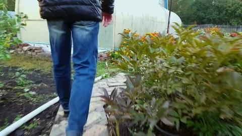 Man slowly walks along the path to the country house Video stock 80419138