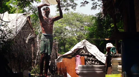 Man in slum taking bath Stock Footage 63556697