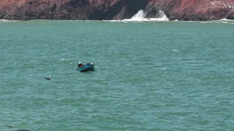 Man in small boat bouncing on choppy water Stock Footage 163837890