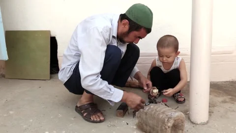 A man with a small child is squatting. Stock Footage 137787379