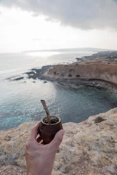 Man with small mate in hand on a Mediterranean beach. Mate is a typical drink Stock Photos