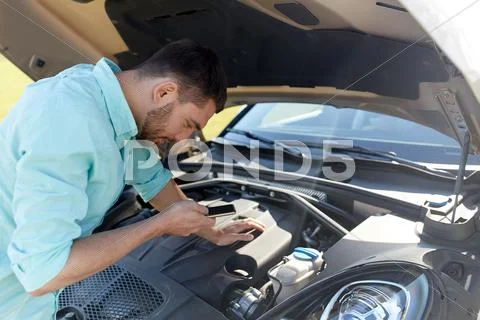 Man with smartphone and broken car at countryside Stock Photos
