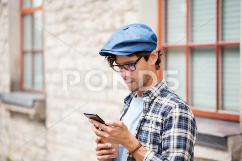 Man with smartphone drinking coffee on city street Stock Photos