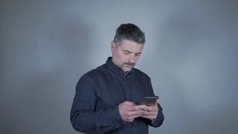 A man on the smartphone on a gray background Stock Footage 129420686