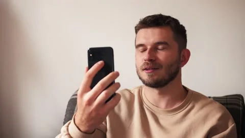 Man with smartphone having video call at home Video stock 141210339
