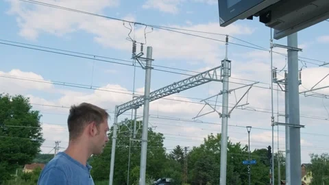 Man with smartphone looking at the train schedule at railway station. Male Stock Footage 269062688