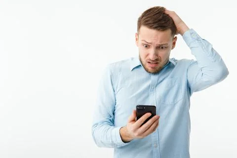 A man with a smartphone is in a panic due to the fall of the cryptocurrency Stock Photos