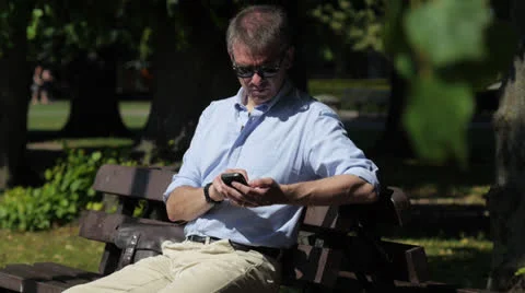 Man with smartphone in park Stock Footage 26355035
