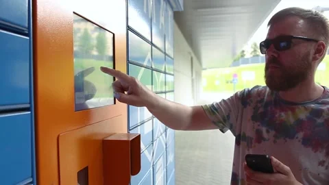 Man with smartphone picks up parcel from automated postal machine. Stock Footage 218146361
