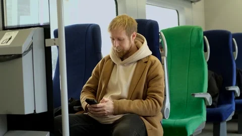 A man with a smartphone sits on a train Video stock 313815735