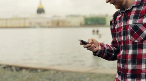 Man With a Smartphone Standing on a Gentle With Views of St. Petersburg Stock-Footage 66078413