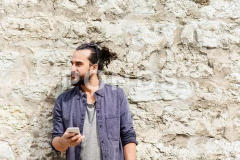 Man with smartphone at stone wall Stock Photos