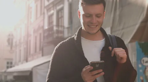 Man with smartphone walking by the city street Stock Footage